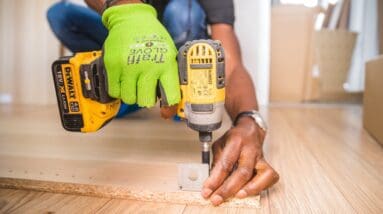 Man drilling nail into floor