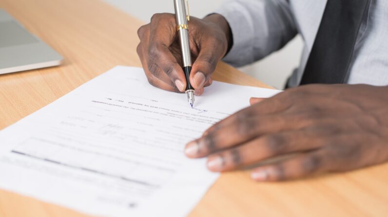 Man holding pen and filling out application