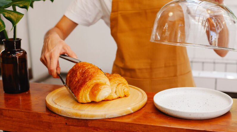Baker placing pastries on a wooden plate