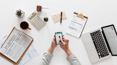 Woman holding phone over desk