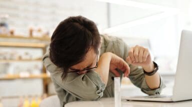 Sick man covering his mouth at work