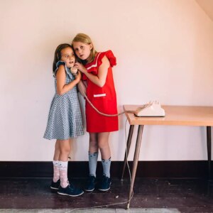 two girls listening on the phone - brand24 social listening