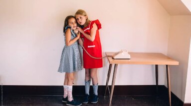 two girls listening on the phone - brand24 social listening